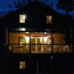 The 2nd story deck of one of our up north 4br family reunion rental glows at night