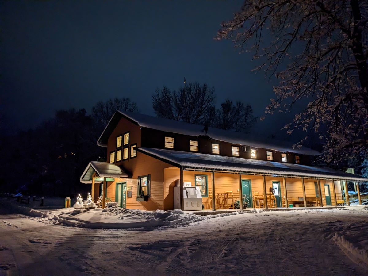 Snowy night landscape with brightly lit lodge
