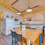 Cute kitchen with refrigerator, microwave, sink, dishwasher and dining area in lake cabin