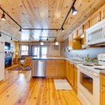 Spacious Pine Wood Kitchen with Oven, Microwave, Dishwasher, Two Refrigerators, and Plenty of Counter Space in Second Floor of Tri Level Cabin