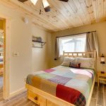 Queen bed with quilt in two bedroom lakeside cabin