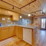 Kitchen with two refrigerators, an oven/stove, microwave and dishwasher on second floor of three story cabin