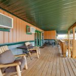 Upper level covered deck with seating and view of the lake