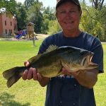 Smiling man holds a largemouth bass