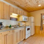 First of two kitchens in resort cabin. Features include full size refrigerator, microwave, and stove. Tiled floors that are equipped with in floor heat.