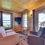 Living room with a TV and a view of Fish Trap Lake from 2br lake cabin rental
