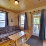 Upstairs living room of lakeside cabin with access to covered upper deck and a beautiful view of the lake