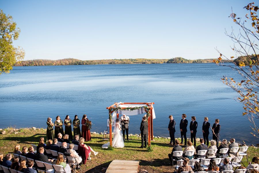 Wedding ceremony under a chuppah on a stunning blue lake on a sunny day wwith blue sky