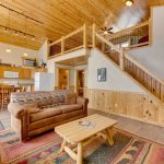 Alternate view of White Oak living/dining space, showing high ceilings and stairs to loft