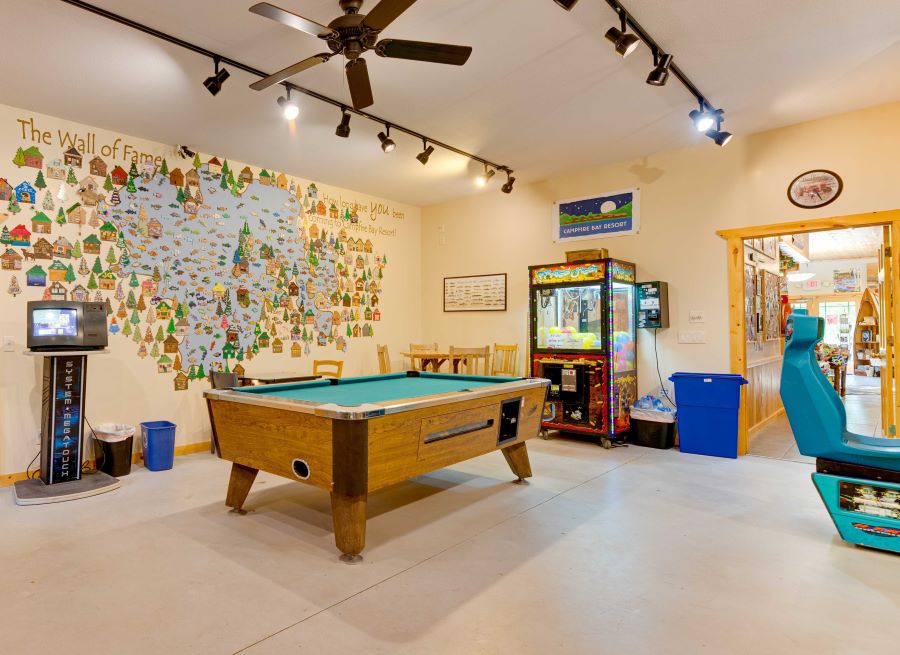Pool table and claw machine in a brightly lit game room