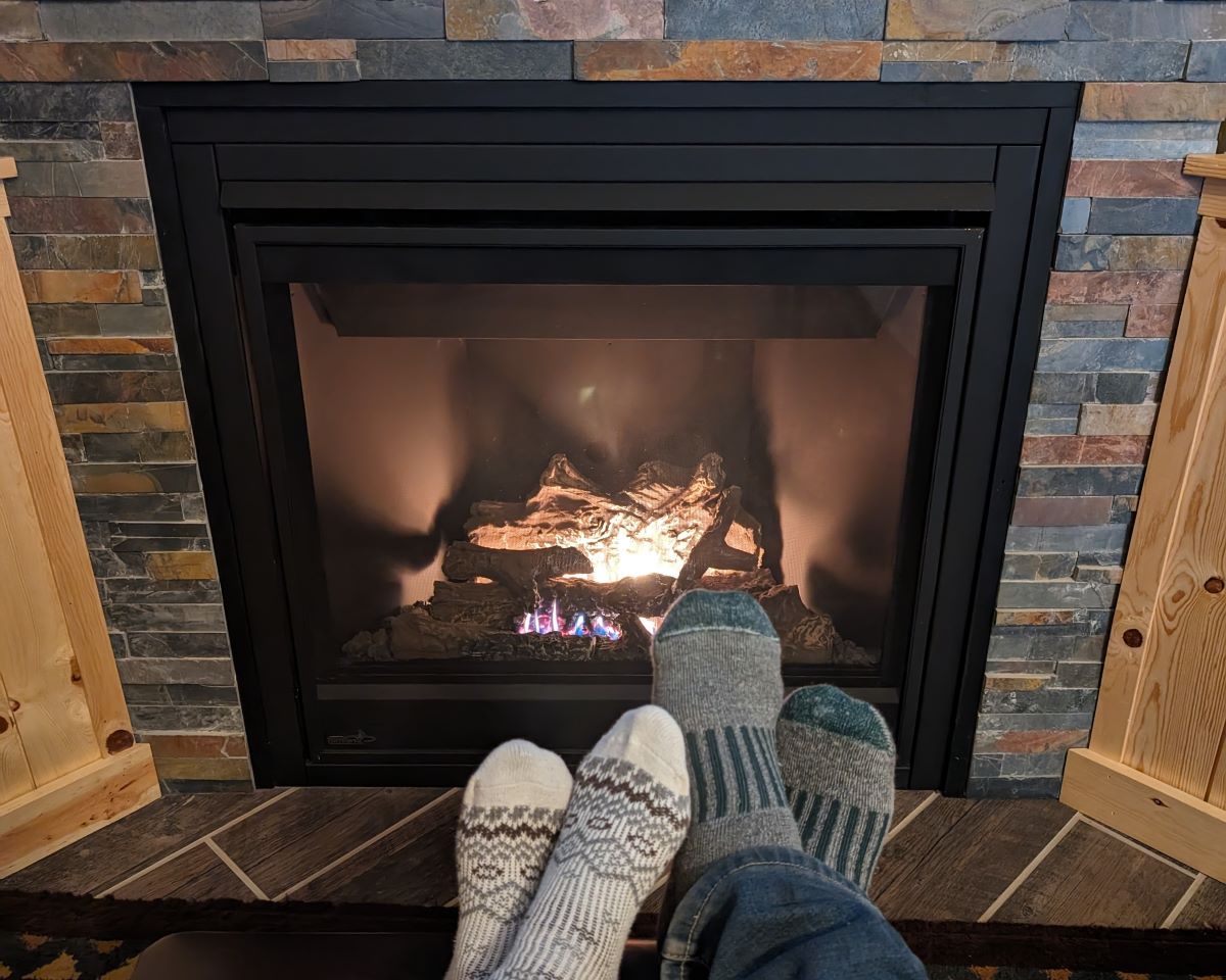 Two feet in front of a fire show how romantic and relaxing a lake cabin in the winter can be.