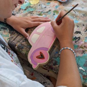 Painting a fun project like this wood car at Campfire Bay Resort painting activity