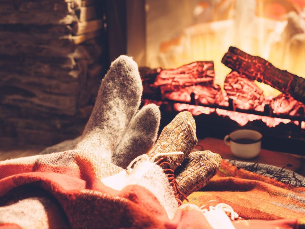 Two feet snuggle by the fire during a romantic cabin getaway at a Minnesota lake resort