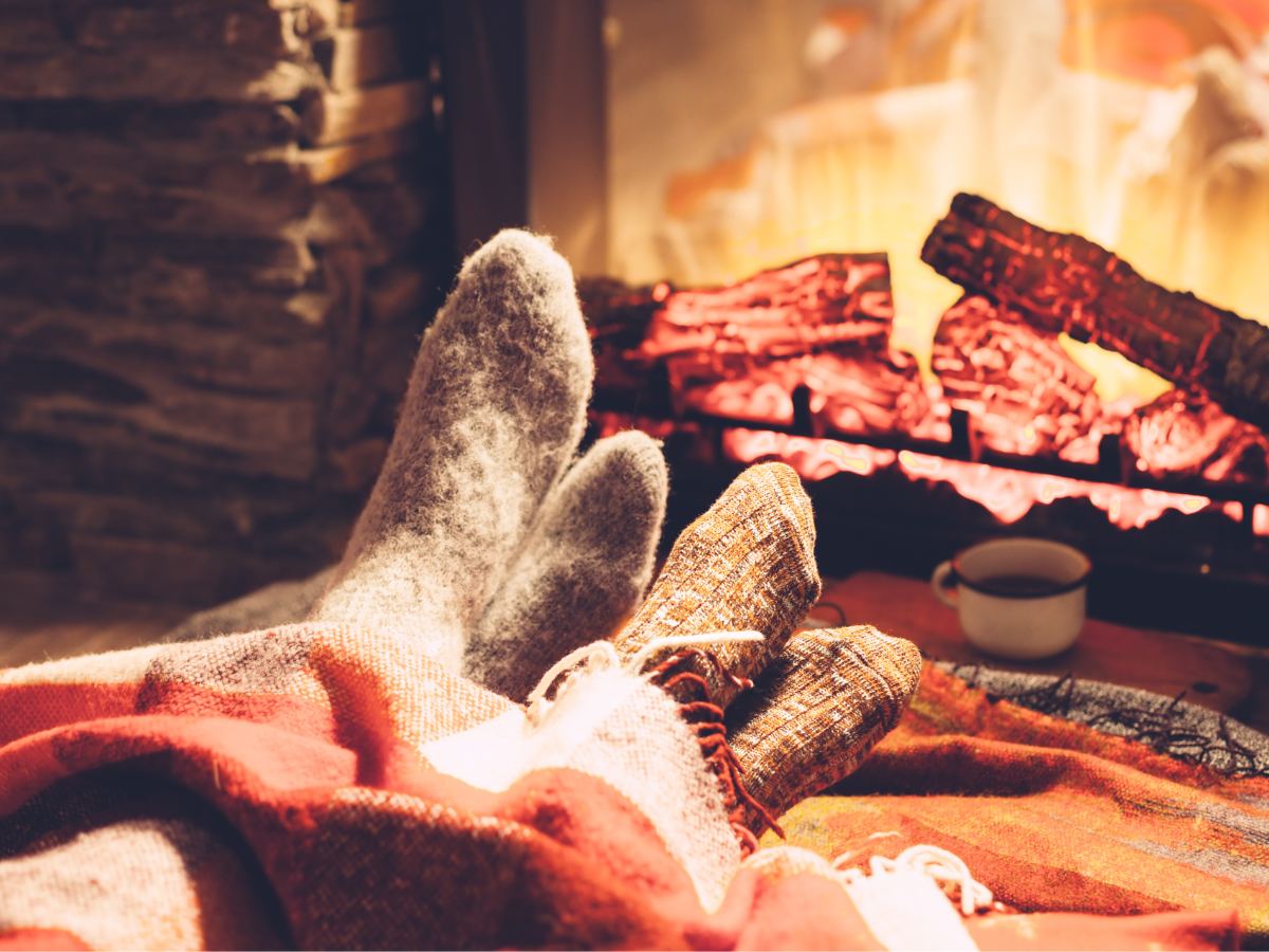 Two feet snuggle by the fire during a romantic cabin getaway