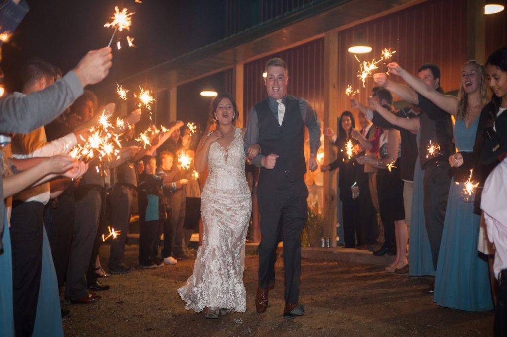 Bride and Groom at wedding processional with sparklers at Campfire Bay rec center near Brainerd, MN