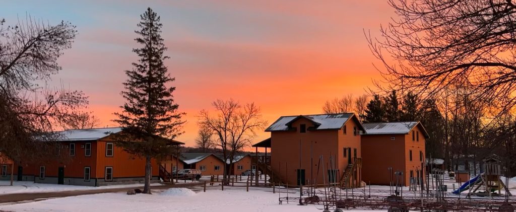 Winter sunset at Campfire Bay Resort casts a warm glow over the year round cabins on the lake