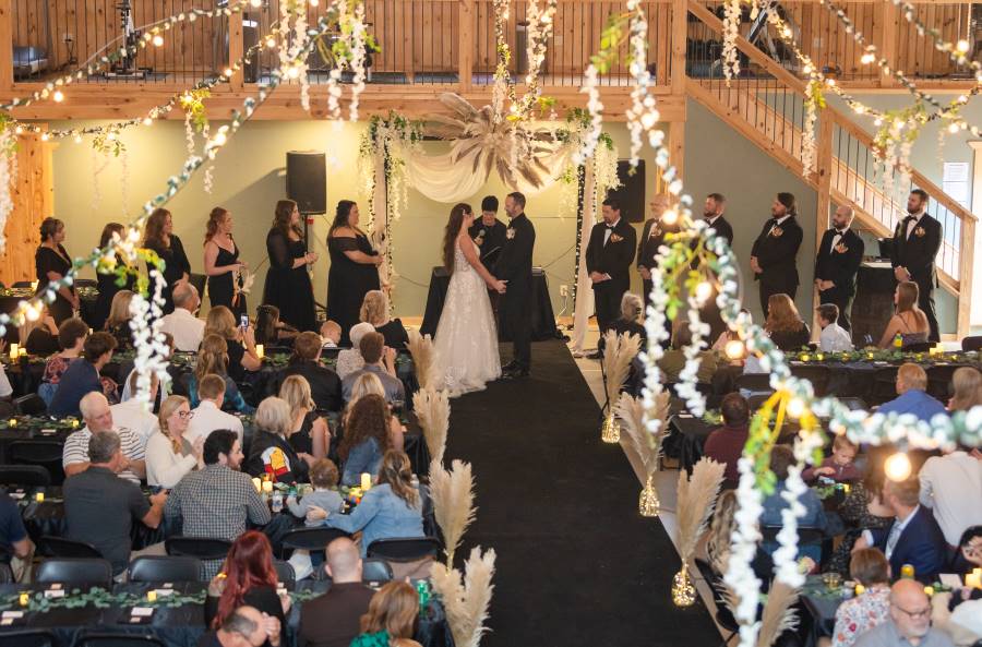 Gorgeous wedding ceremony with dangling white lights in northwoods MN lakeside resort venue