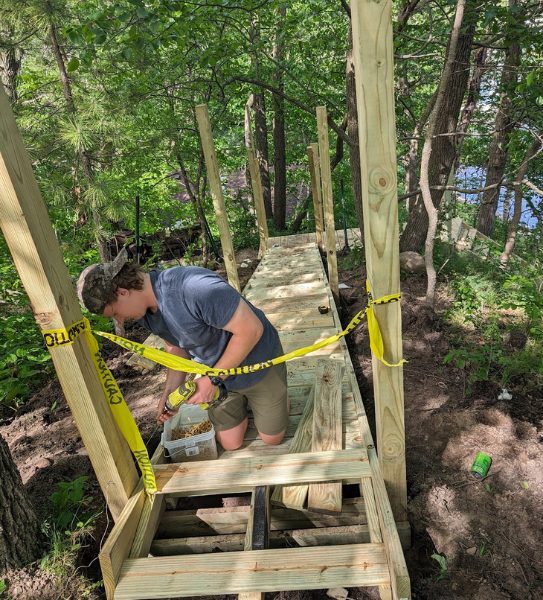 A member of the maintenance staff at Campfire Bay Resort builds a new staircase down to the lake.