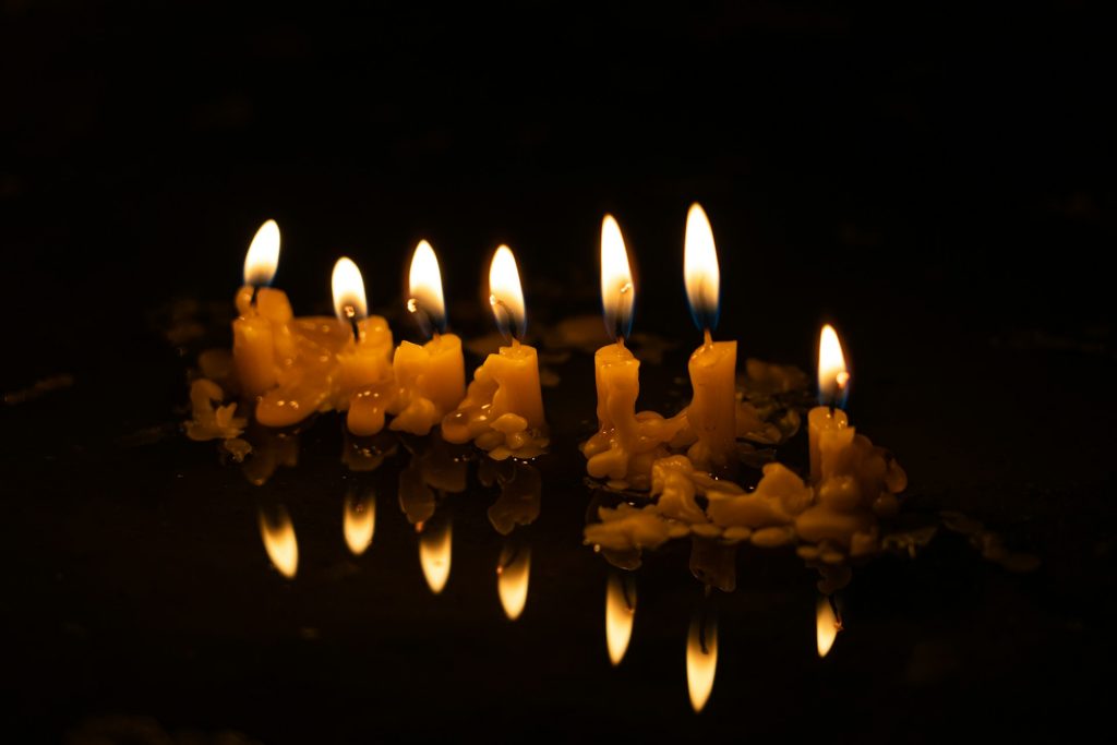 Image of small candles glowing against a black background