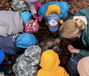 kids and instructor inspecting soemthing on the ground