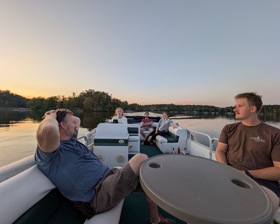 A family relaxes on a pontoon at sunset