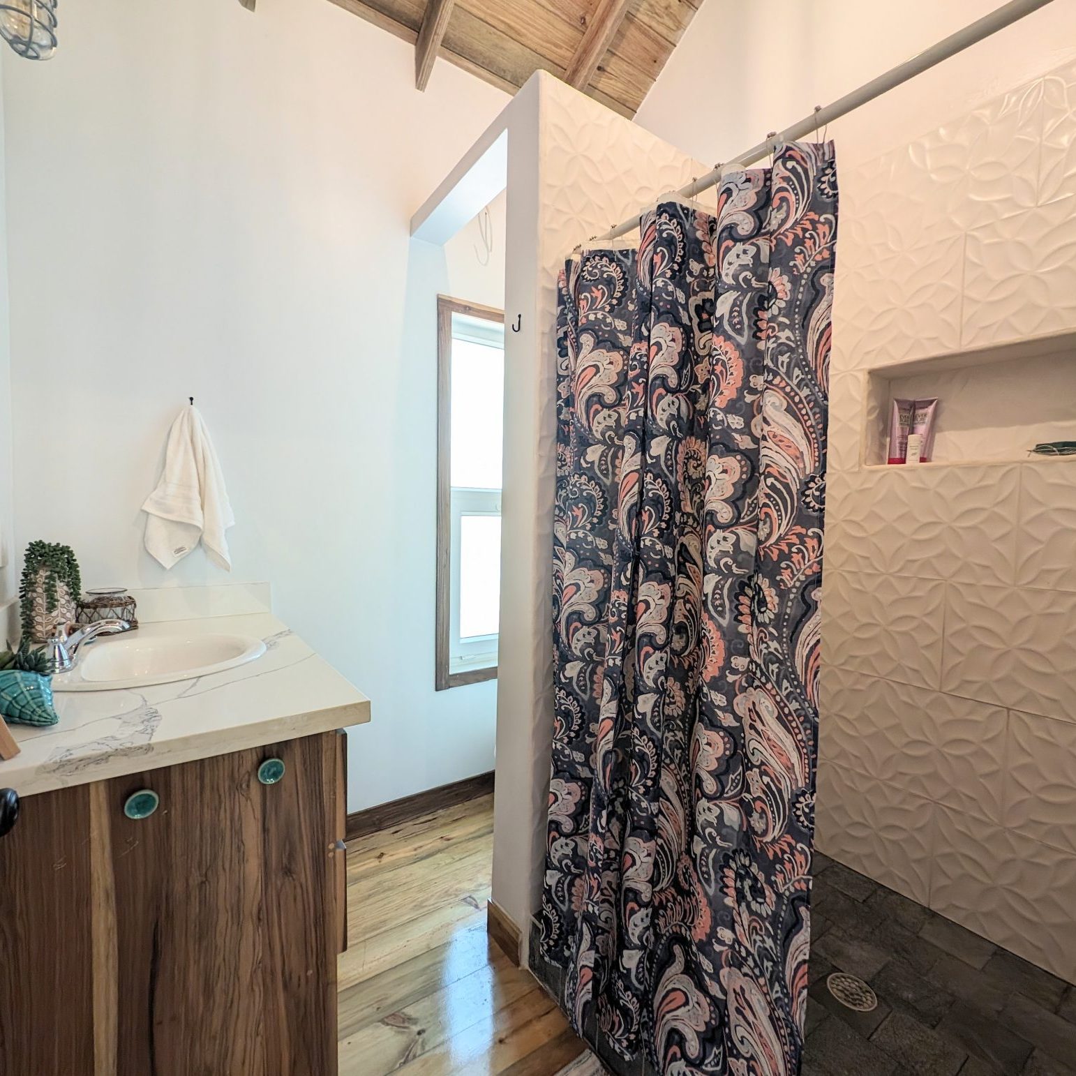 2BR Caribbean cabin with spacious tiled shower, large vanity, and toilet hidden from entrance