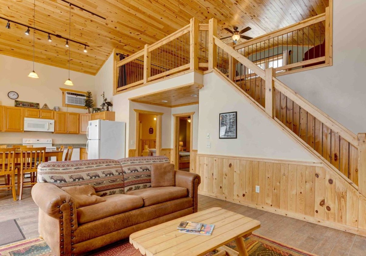 Alternate view of White Oak living/dining space, showing high ceilings and stairs to loft
